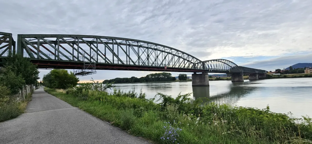 Die Donaubrücke Stein-Mautern, Blick von der Uferpromenade auf das stählerne Fachwerk über der Donau.